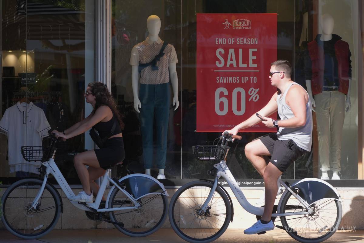 $!Un ciclista pasea cerca de un puesto con ofertas de fin de temporada, el viernes 9 de enero de 2026, en Miami Beach, Florida.