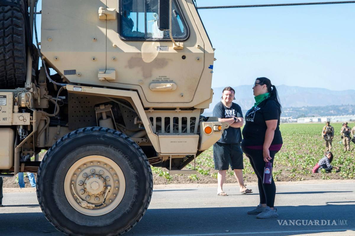 $!Rebecca Torres se encuentra frente a un vehículo militar que se acerca a una redada de agentes federales de inmigración en el área agrícola de Camarillo.