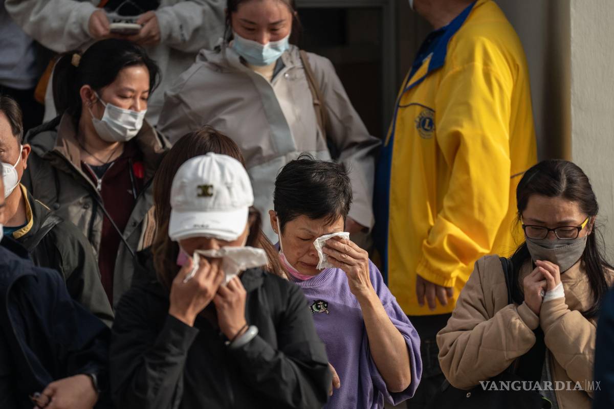 $!Personas con familiares desaparecidos reaccionan después de revisar fotografías de los fallecidos en Tai Po, Hong Kong.