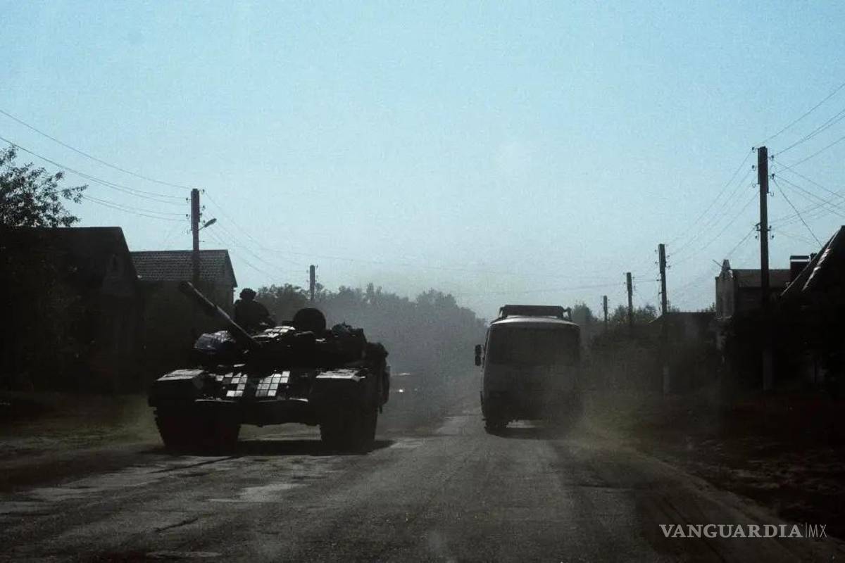 $!Un autobús civil circulaba el pasado mes de agosto junto a un tanque ucraniano a 9 kilómetros de la frontera con Rusia, en la región ucraniana de Sumi.