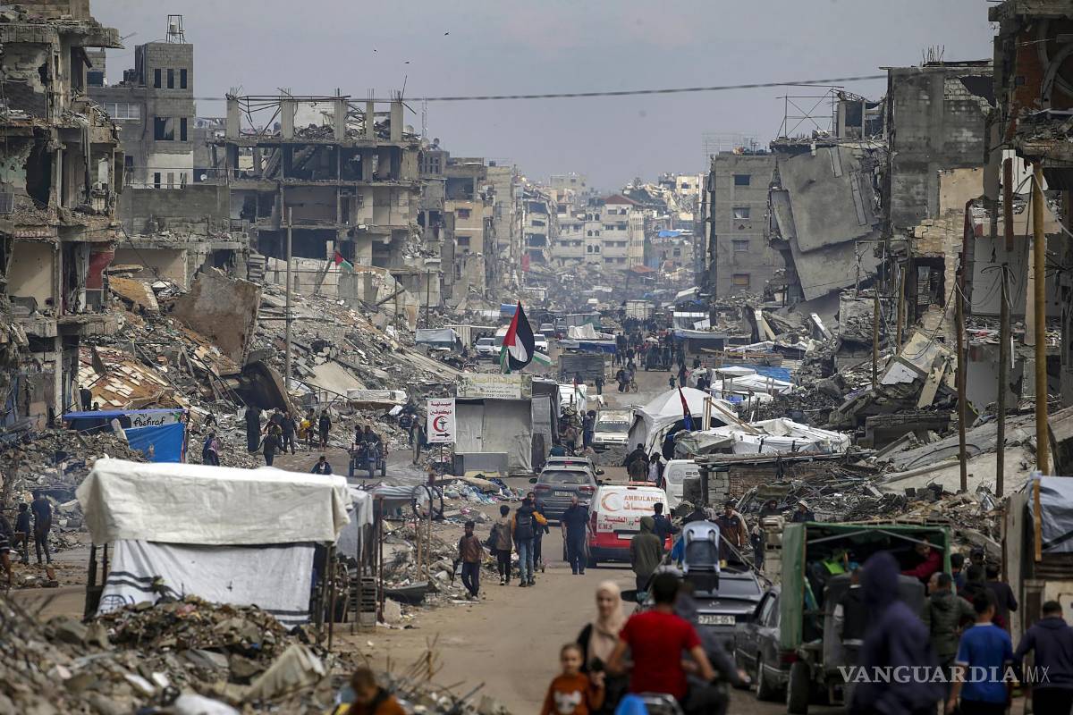 $!Palestinos caminan entre refugios improvisados y las ruinas de edificios residenciales destruidos a lo largo de la calle Al-Jalaa’, en la ciudad de Gaza.