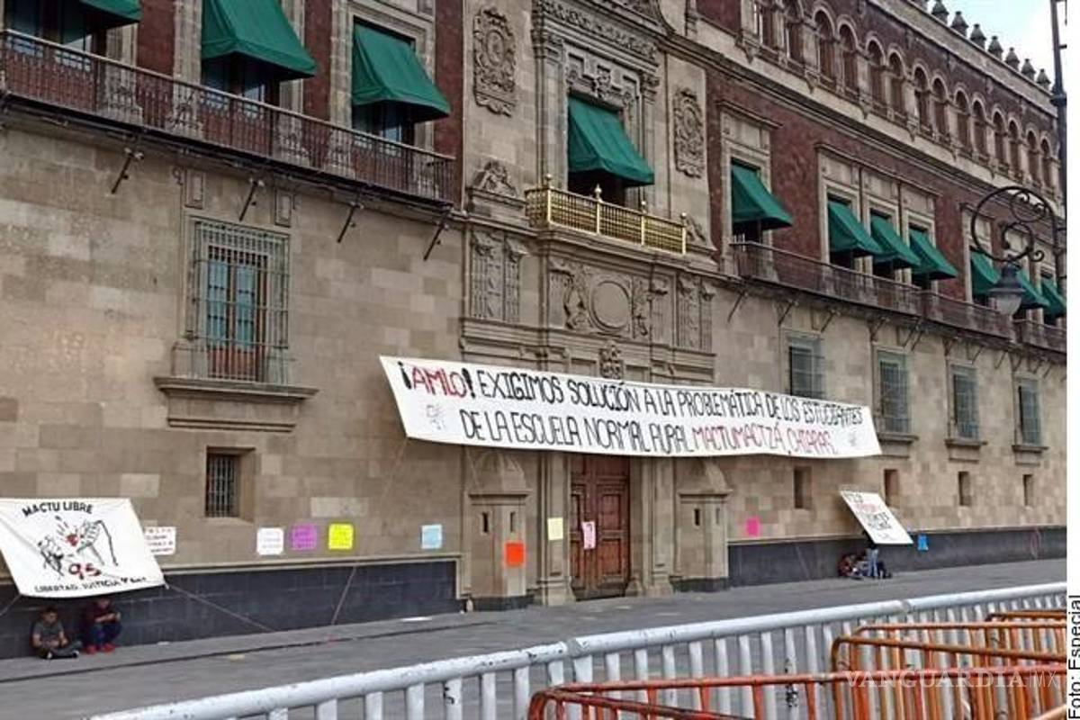 Normalistas de Chiapas saltan vallas de Palacio Nacional y colocan manta