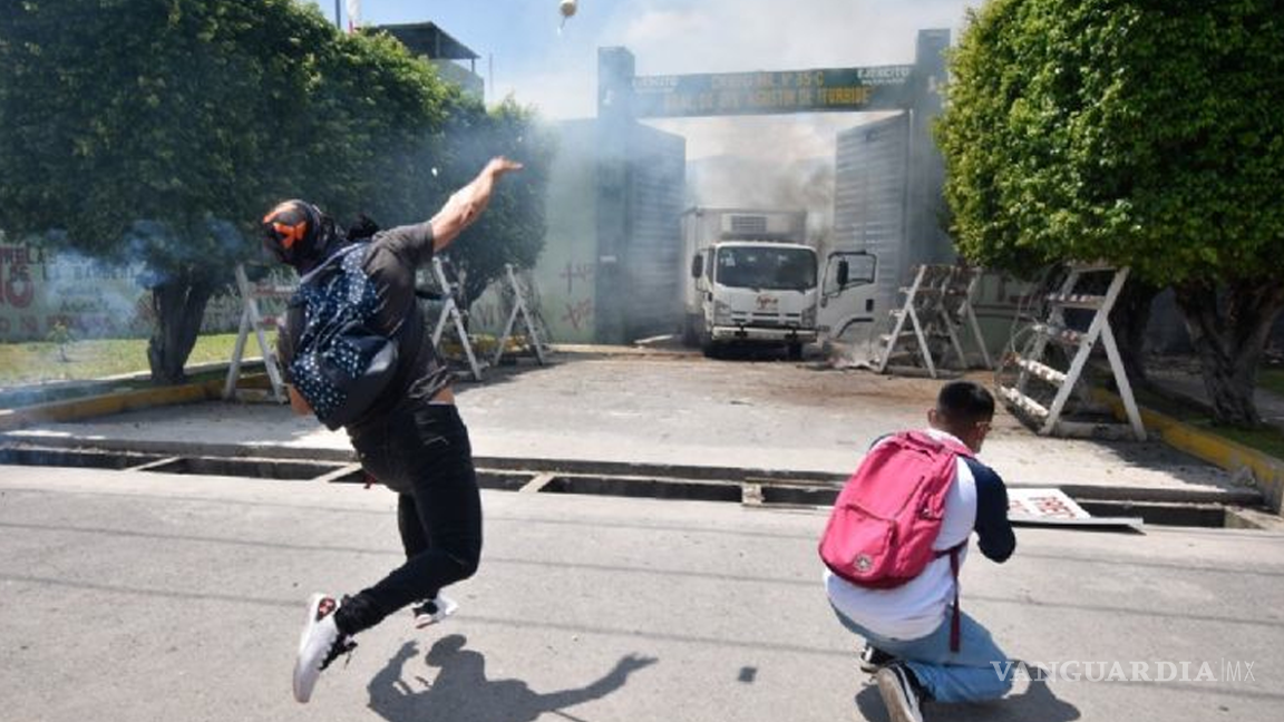 $!Siguen protestas de normalistas de Iguala, queman camión y destruyen fachada del 27 batallón