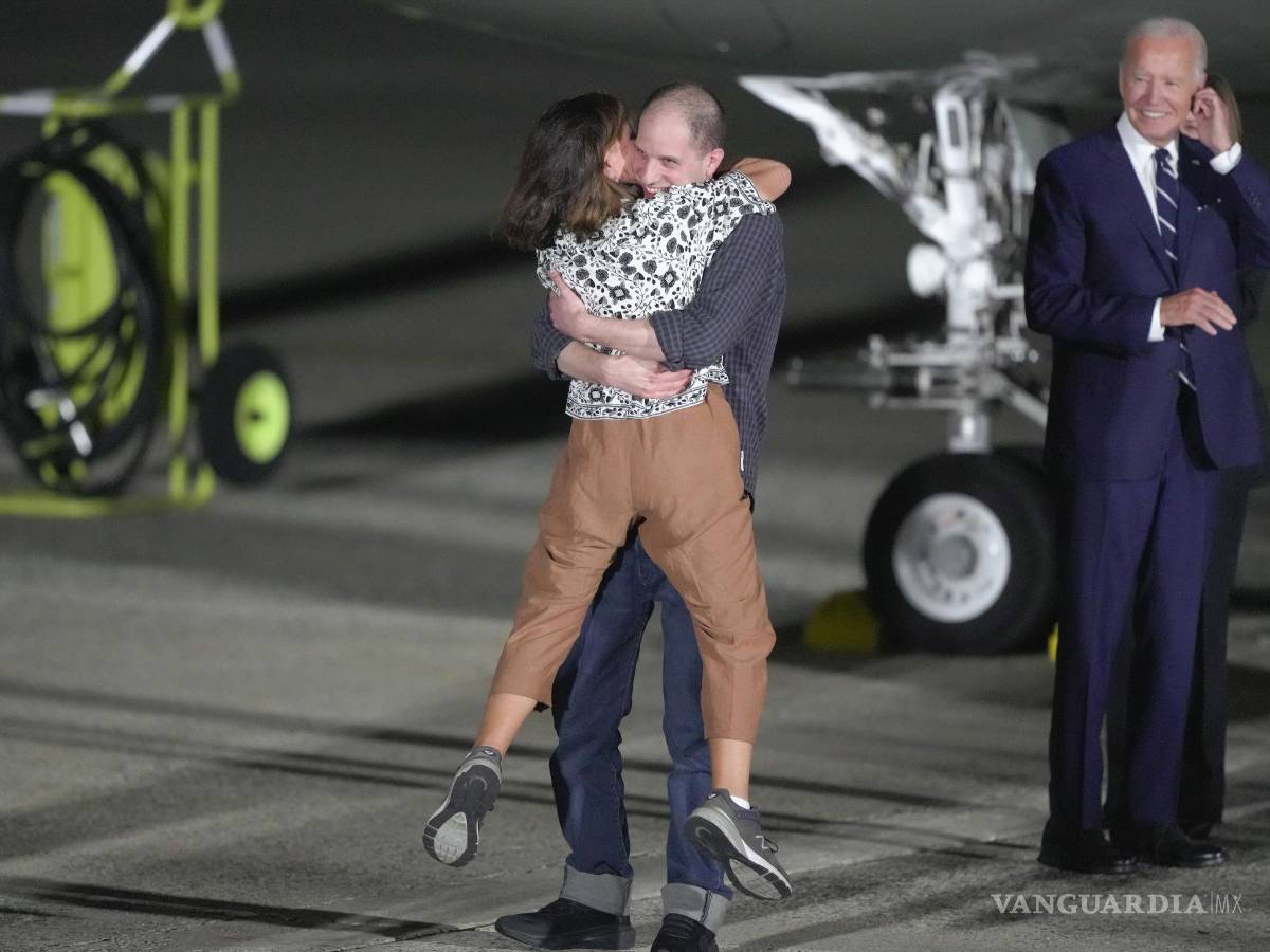$!Evan Gershkovich abraza a su madre, Ella Milman, mientras el presidente Joe Biden, a la derecha, observa en la Base de la Fuerza Aérea Andrews, Maryland.