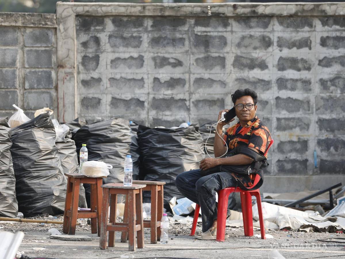 $!Un familiar espera a sus familiares desaparecidos durante una operación de búsqueda de sobrevivientes en el lugar de un edificio derrumbado en Bangkok.