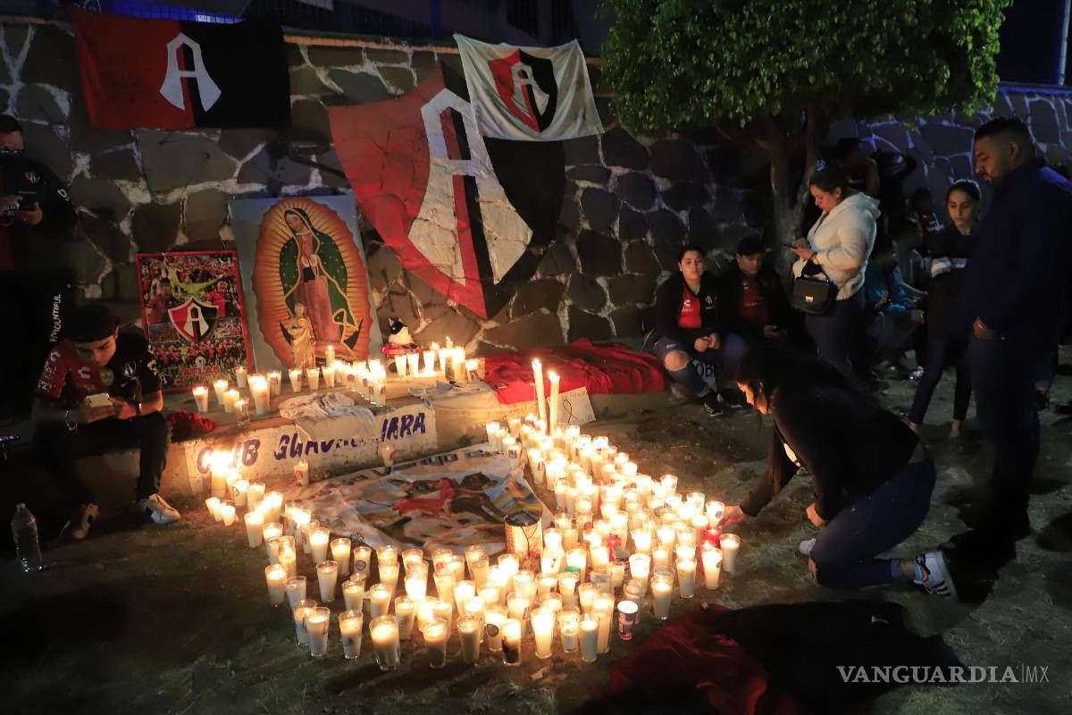 $!Aficionados del Club Atlas, encienden velas en la madrugada de este domingo, en las inmediaciones del estadio Jalisco, en la ciudad de Guadalajara, debido a los actos de violencia ocurridos en el partido.