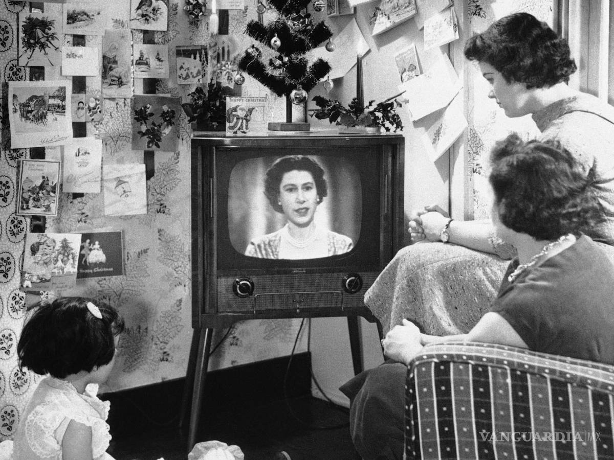 $!Una familia de Londres mira a la reina Isabel II en una pantalla de televisión durante el primer discurso de Navidad de la reina el 26 de diciembre de 1957. AP