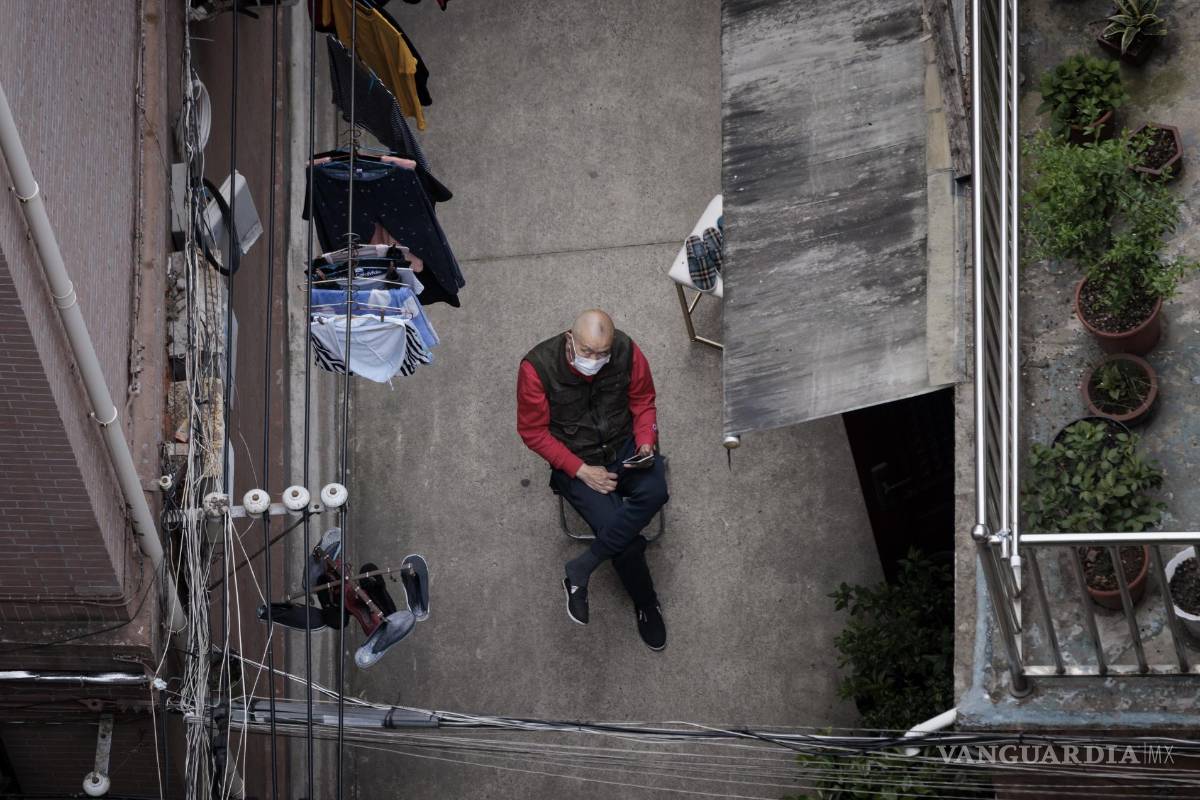 $!Un hombre se sienta afuera de su casa en un complejo residencial en Shanghái, China.