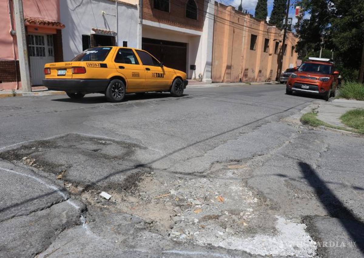 $!Automovilistas intentan evitar los daños en la vialidad, lo que pone en riesgo los vehículos estacionados a los lados.