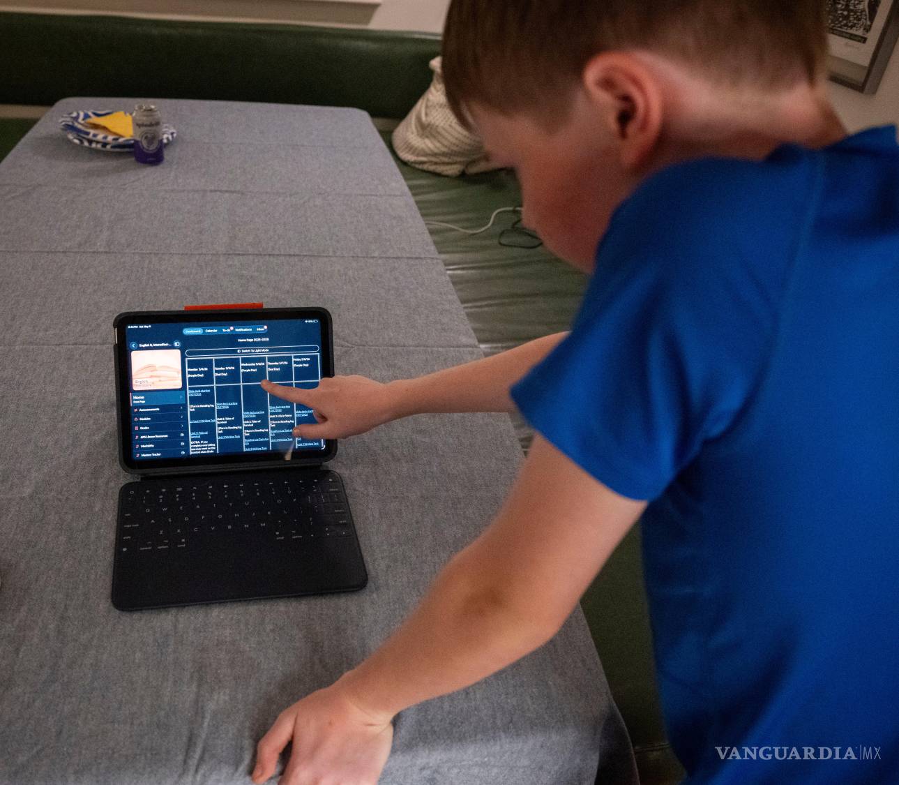 $!El hijo de LuAnn Oliver muestra cómo usa un iPad para sus clases durante una reunión en la que un grupo de padres de alumnos en Arlington, Virginia.