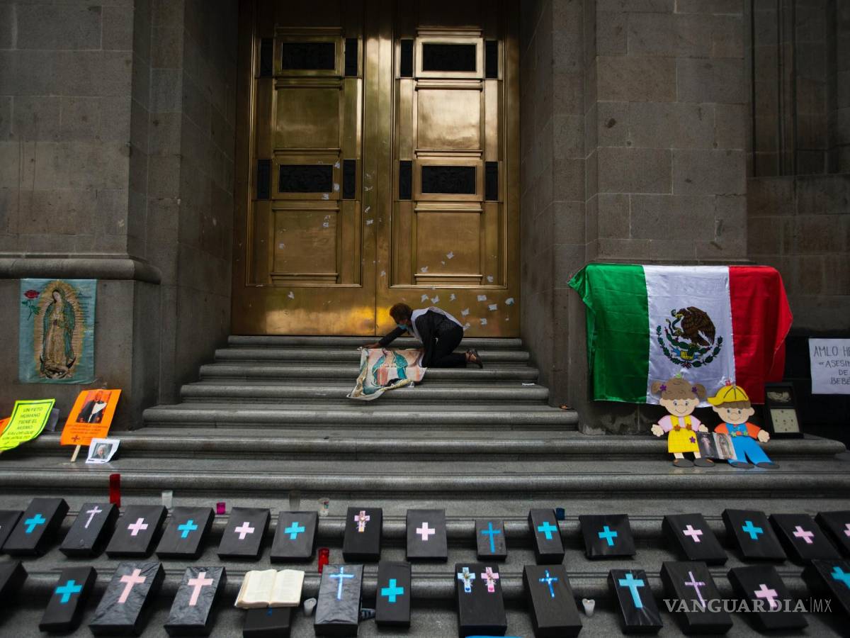 $!Activista contra el aborto coloca un panel de tela de Nuestra Señora de Guadalupe junto a pequeños ataúdes simulados en la entrada de la Corte Suprema.