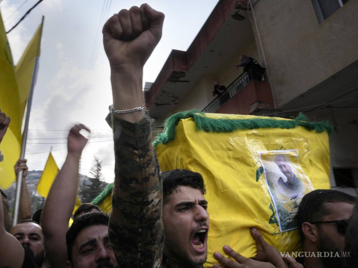 $!Un combatiente de Hezbollah carga el ataúd de uno de sus compañeros que murió por artillería israelí, mientras grita consignas durante una procesión fúnebre, el martes 10 de octubre de 2023, en el poblado de Khirbet Selm, en el sur de Líbano. El grupo respaldado por Irán anunció el lunes por la noche que tres de sus elementos murieron luego de un intenso bombardeo israelí contra distintos poblados en el sur de Líbano. (AP Foto/Hussein Malla)