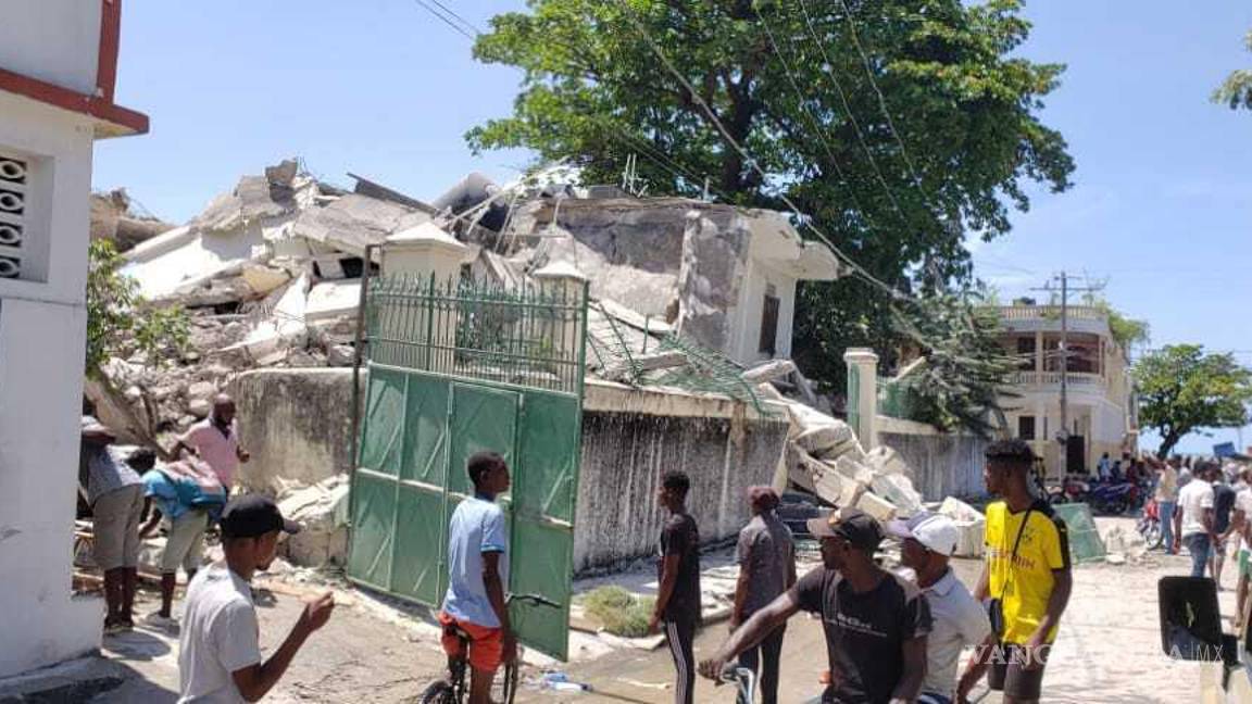 $!La gente se para frente a la residencia del obispo católico después de que fuera dañada por un terremoto en Les Cayes, Haití. AP/Delot Jean