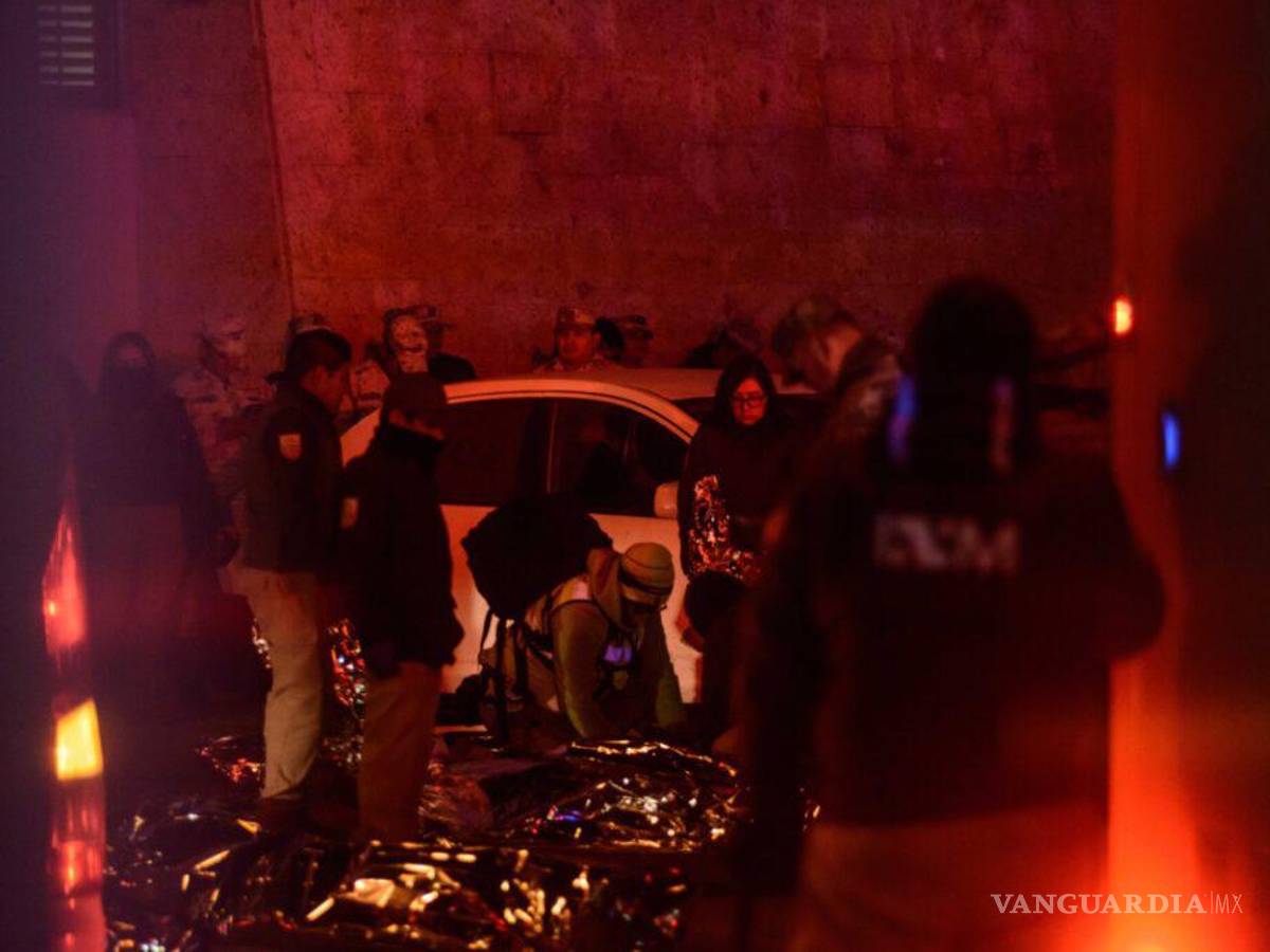 $!Peritos revisan los cuerpos de migrantes cubiertos con colchas térmicas de aluminio.