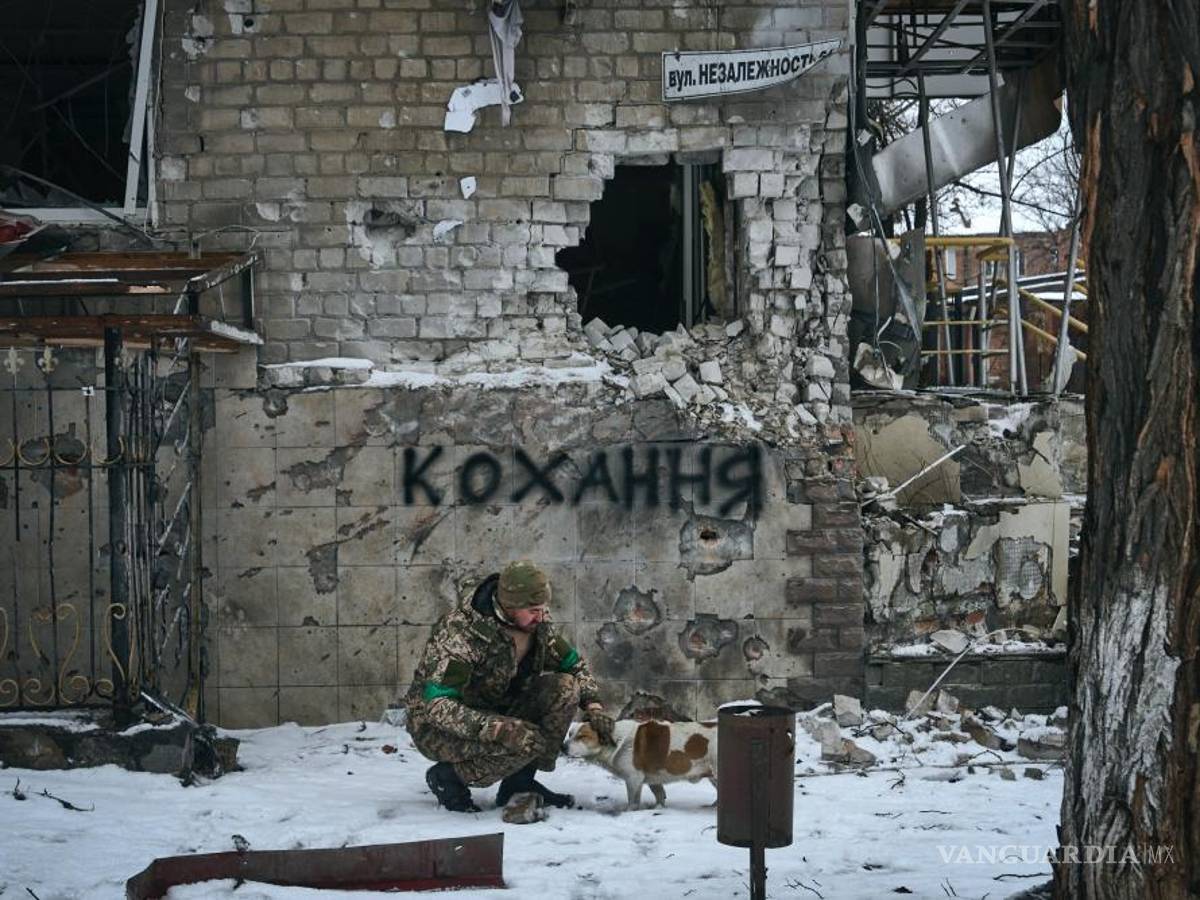 $!Un soldado ucraniano acaricia a un perro en Bakhmut, Ucrania. El letrero en la pared dice “Amor”, el letrero de la calle dice “Calle de la Independencia”.