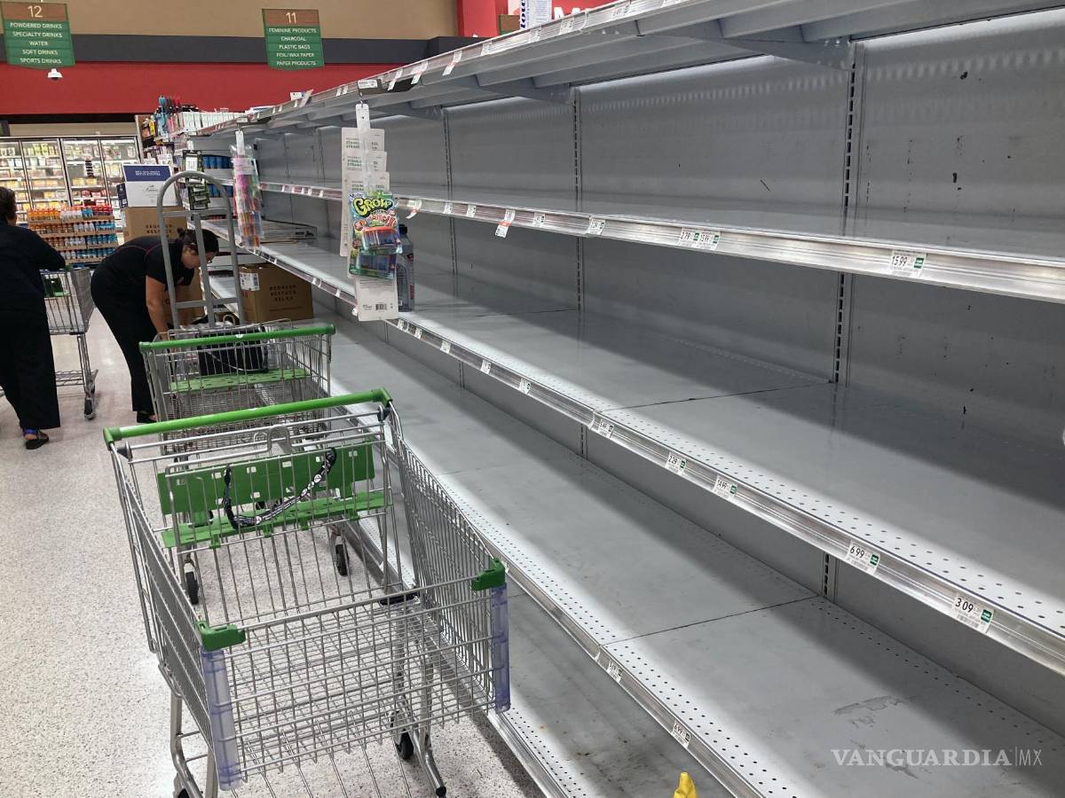 $!A medida que el huracán Ian se acerca a Florida, los carritos de compras quedan abandonados junto a los estantes vacíos en un supermercado en Orlando, Florida.