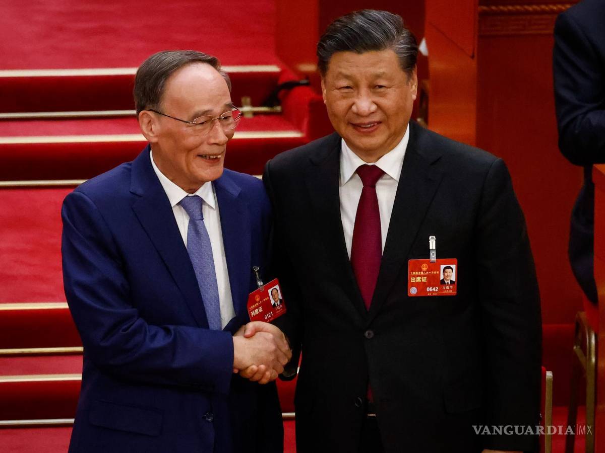 $!El presidente chino, Xi Jinping (d), le da la mano al vicepresidente Wang Qishan (i) durante la Tercera Sesión Plenaria de la Asamblea Popular Nacional en Beijing.
