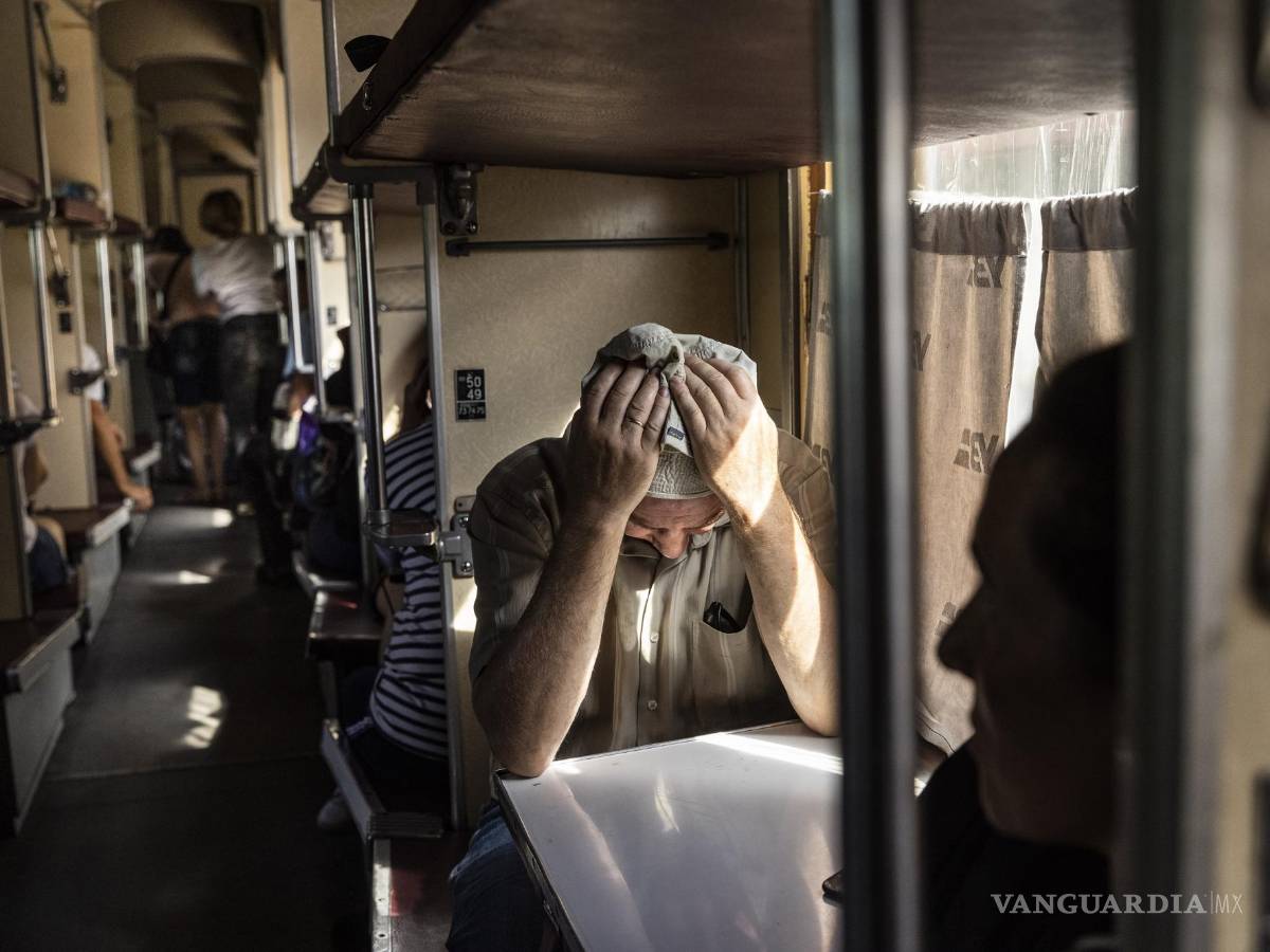 $!Un hombre sostiene su cabeza entre sus manos mientras toma asiento en un tren que evacua a los residentes de Pokrovsk, Ucrania.