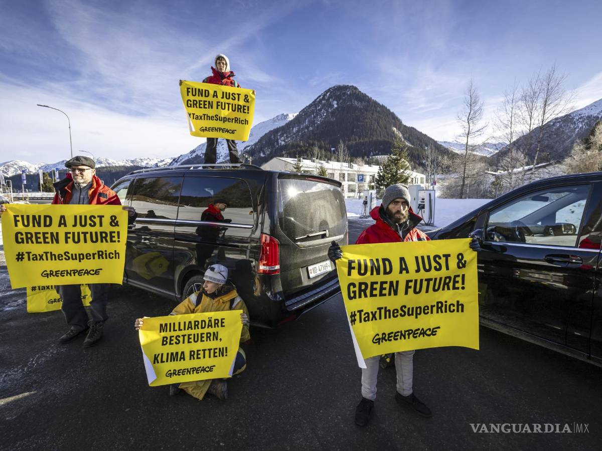 $!Activistas de Greenpeace bloquean el camino de acceso al helipuerto durante una protesta en Davos Dorf durante la 55ª reunión anual del Foro Económico Mundial.