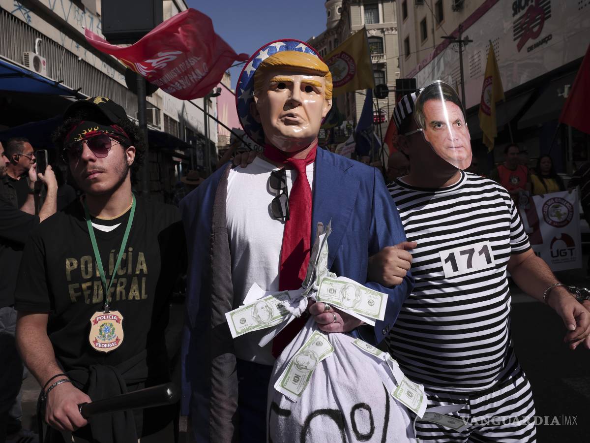 $!Manifestantes vestidos de policías escoltan a Donald Trump y a Jair Bolsonaro para protestar contra el anuncio de Trump de imponer aranceles del 50%.