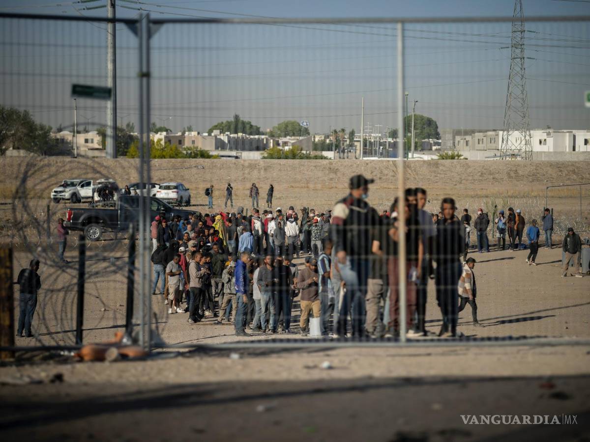 $!Migrantes hacen fila en un campamento de migrantes para ser registrados por agentes de la Patrulla Fronteriza antes de ser procesados en El Paso, Texas.