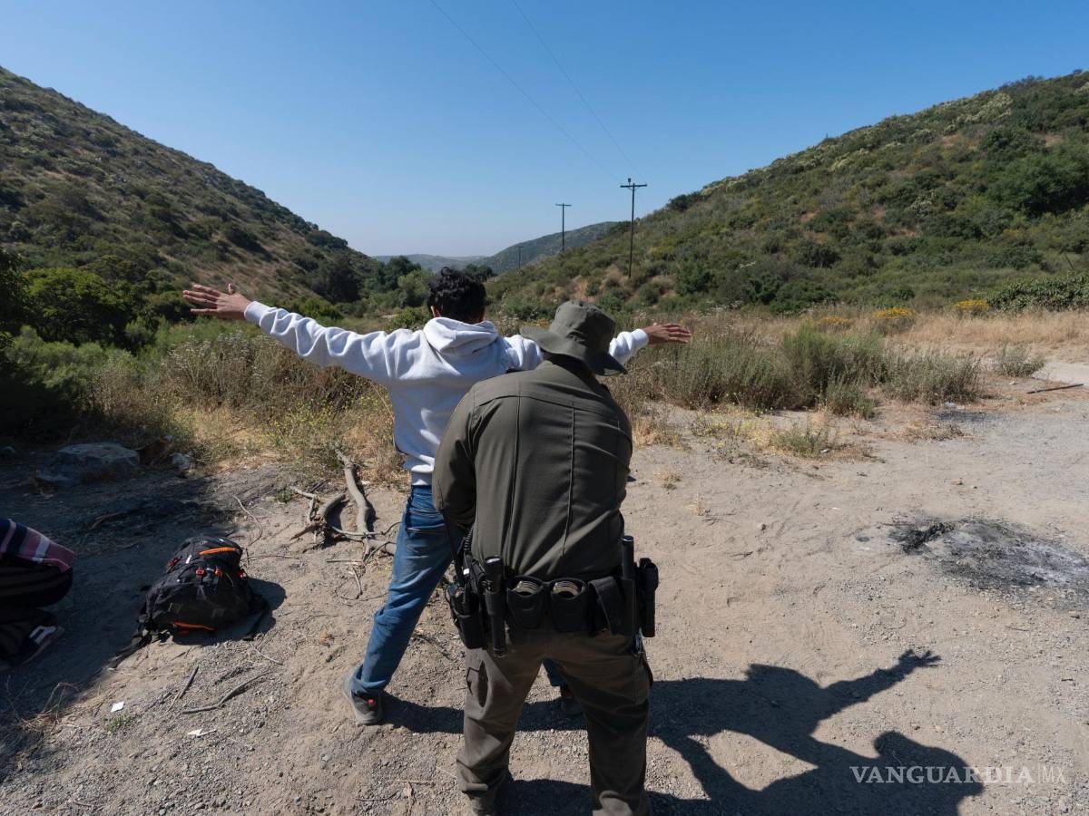 $!Un agente de la Patrulla Fronteriza revisa a un migrante que busca asilo antes de que lo transporten y procesen erca de Dulzura, California.