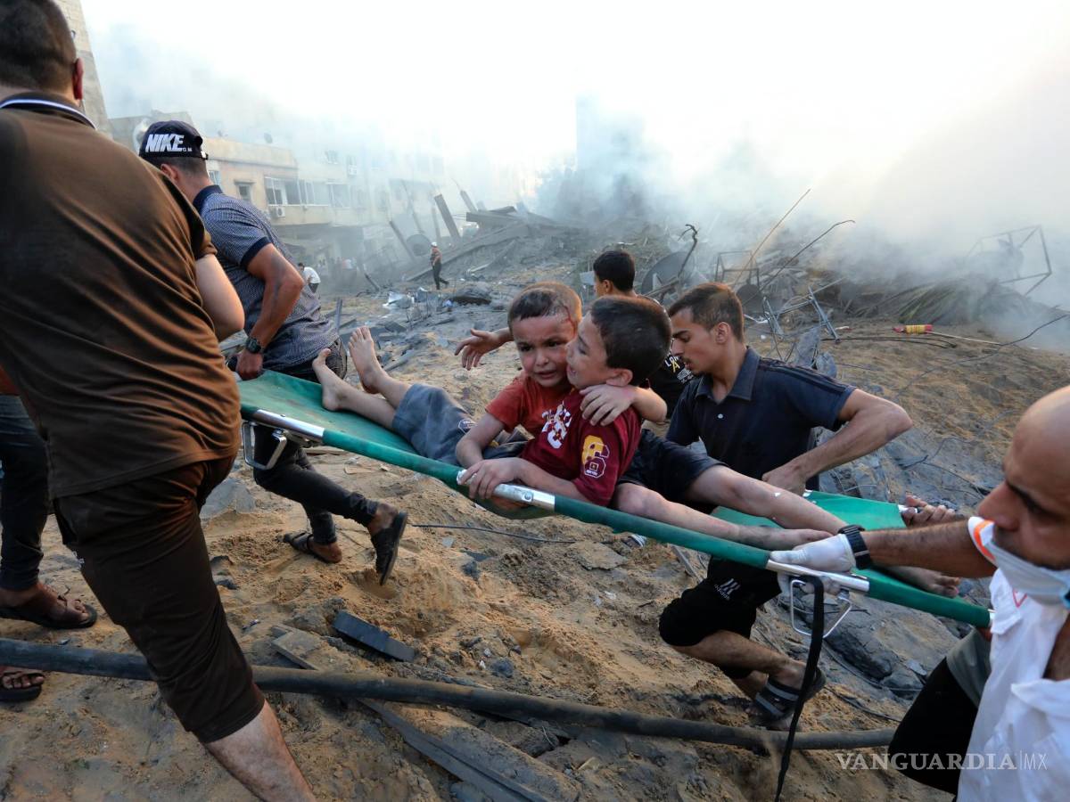 $!Palestinos sacan a dos niños heridos en un ataque aéreo israelí sobre la Ciudad de Gaza, el 25 de octubre de 2023.