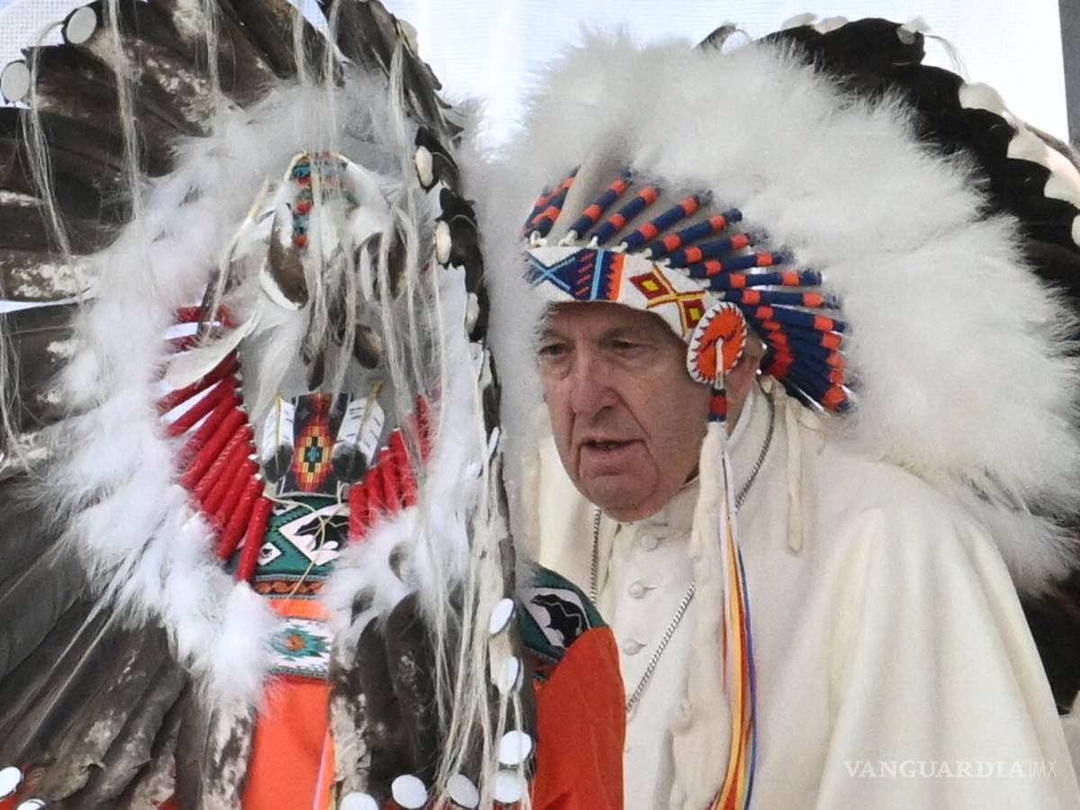 $!El Papa Francisco recibe un tocado indígena en una reunión con indígenas para una oración silenciosa en el cementerio de Maskacis en Edmonton, Canadá.