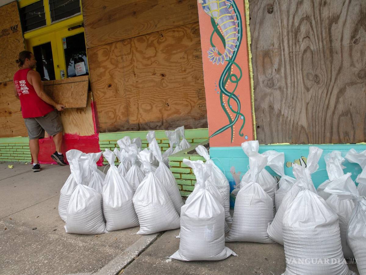 $!Residentes de Gulfport Beach colocan madera contrachapada mientras se preparan para el huracán Ian en Gulfport, Florida.