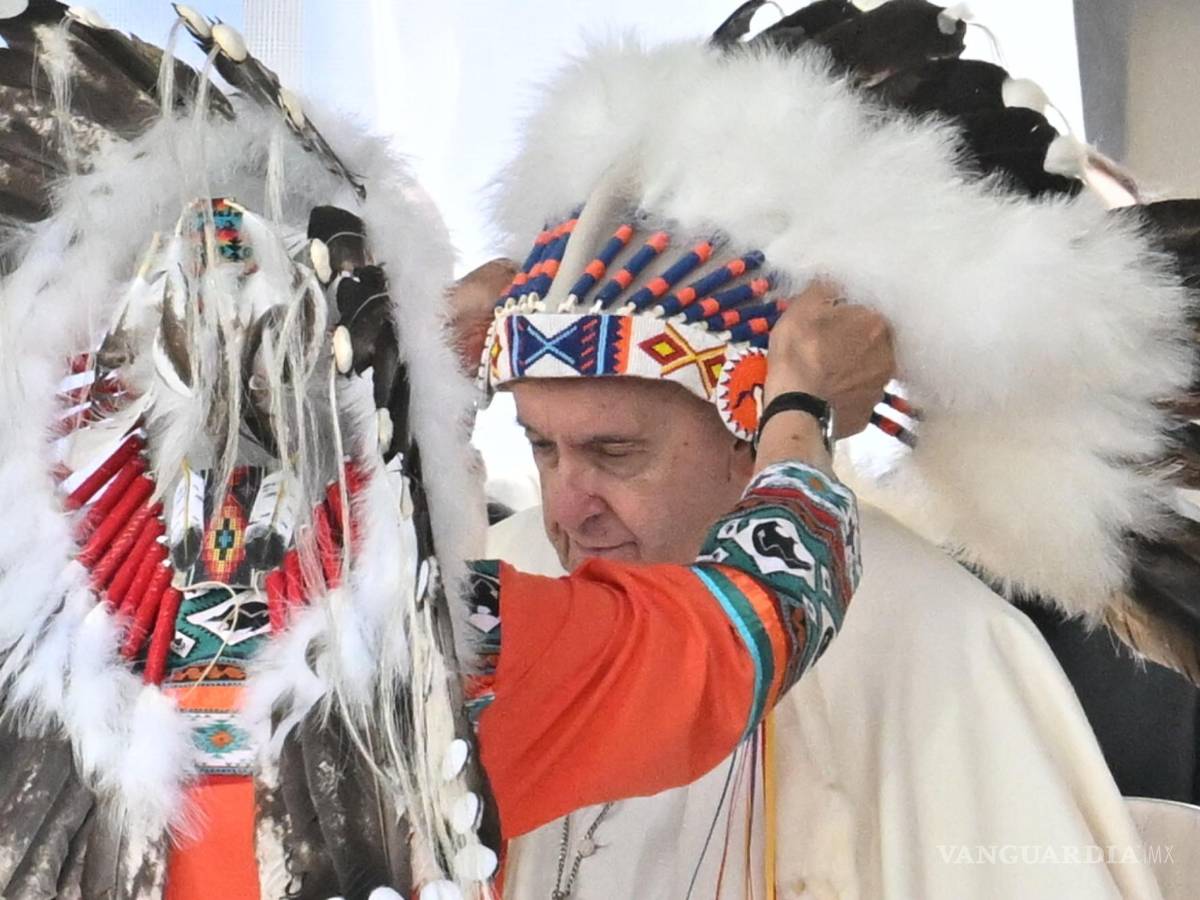 $!El Papa Francisco recibe un tocado indígena en una reunión con indígenas para una oración silenciosa en el cementerio de Maskacis en Edmonton, Canadá.