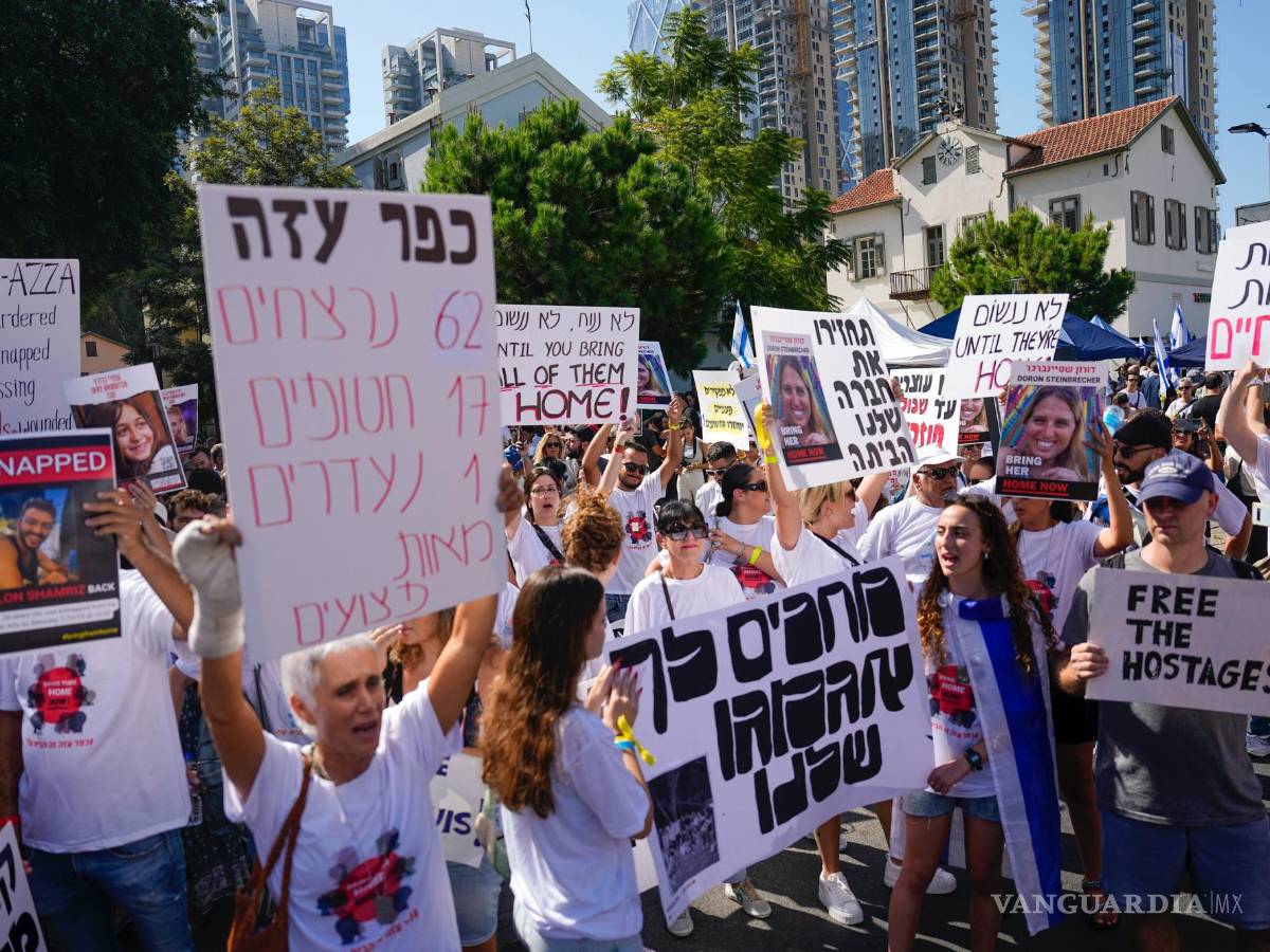 $!Residentes del kibutz Kfar Azza atacada por Hamás, sostienen fotografías de sus seres queridos, piden el regreso de más de 220 rehenes, en Tel Aviv, Israel.