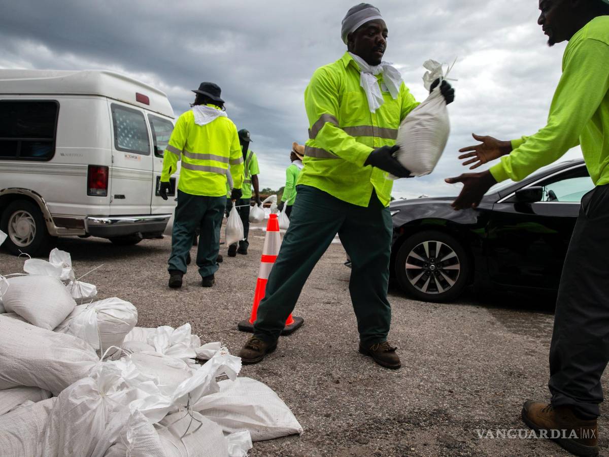 $!Trabajadores y voluntarios de la ciudad de St Petersburg en Florida entregan sacos de arena a los residentes mientras la ciudad se prepara para el huracán Ian.