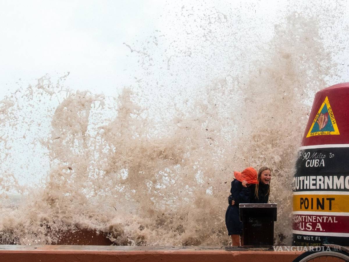 $!Los visitantes de la boya de Southernmost Point desafían las altas olas del huracán Ian para tomar fotos en Key West, Florida.