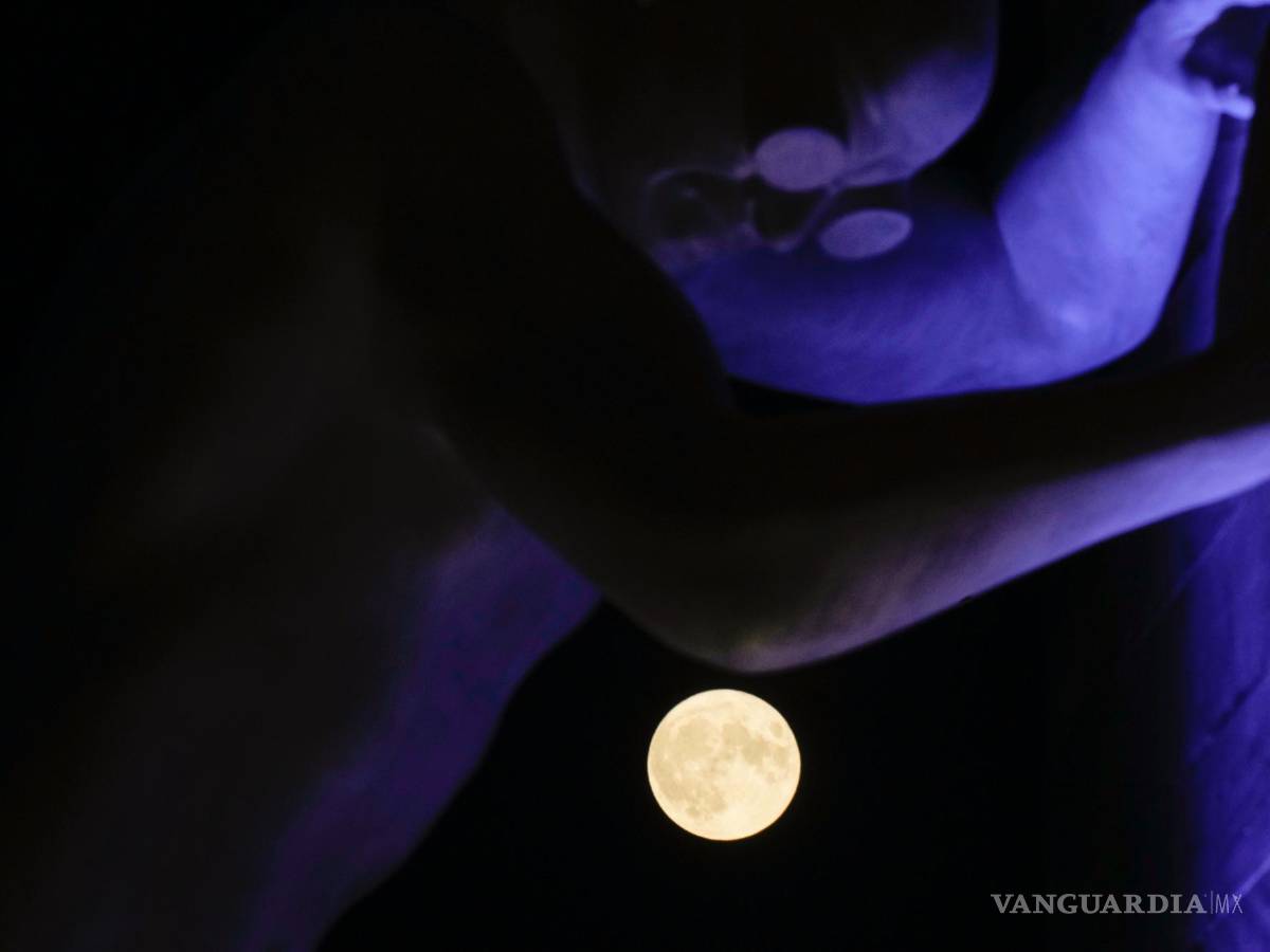 $!La luna llena, vista detrás de la escultura Mr Arbitrium, del artista Emanuele Giannelli, que se apoya en el Arco de la Paz, en Milán, Italia, el 13 de julio de 2022.