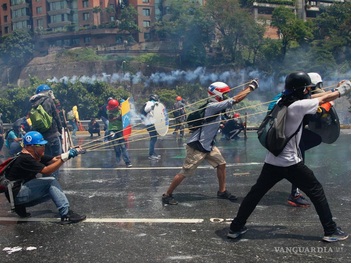$!Manifestantes contra el gobierno lanzan una botella con material fecal a las fuerzas de seguridad que impiden el paso de la marcha rumbo a la Corte Suprema.