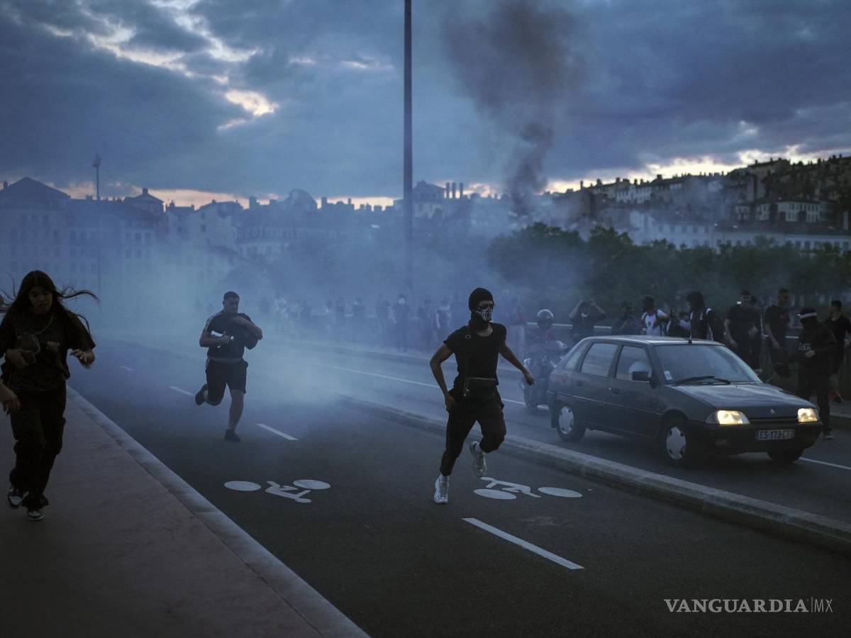 $!Varias personas salen corriendo durante disturbios con la policía en el centro de Lyon.