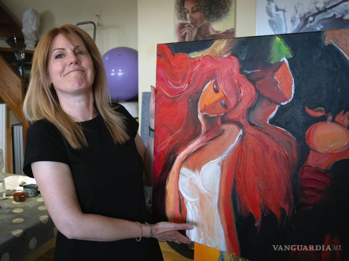 $!Vita Kahaniuk sostiene su pintura que creó para conmemorar a su esposo, un soldado que murió en una batalla con las tropas rusas en Kiev.