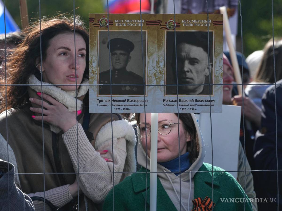 $!Personas con retratos de familiares que lucharon en la Segunda Guerra Mundial en la Plaza del Palacio en San Petersburgo, Rusia.