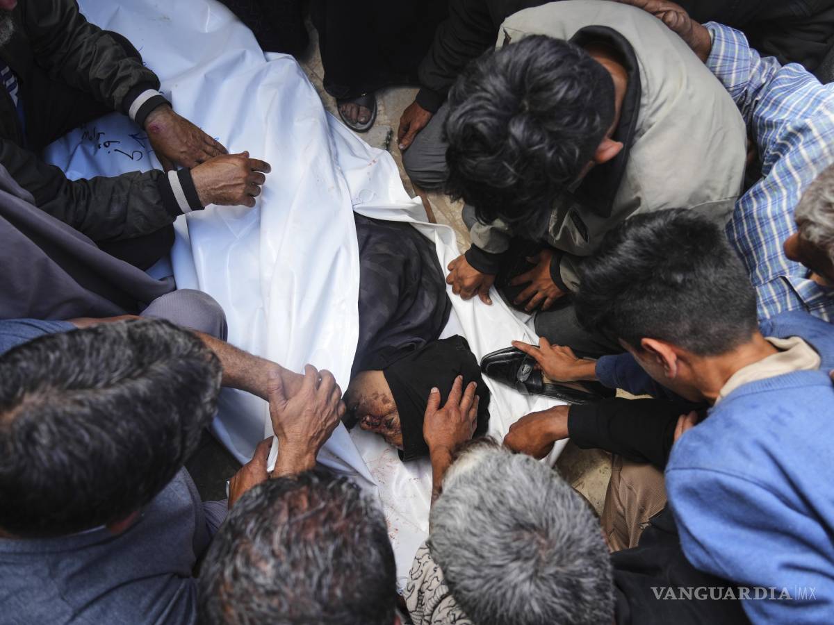 $!Palestinos lloran sobre el cuerpo de Al-Akhras, que murió cuando se dirigía a un centro de ayuda en Gaza, durante su funeral en el Hospital Nasser en Jan Yunis.