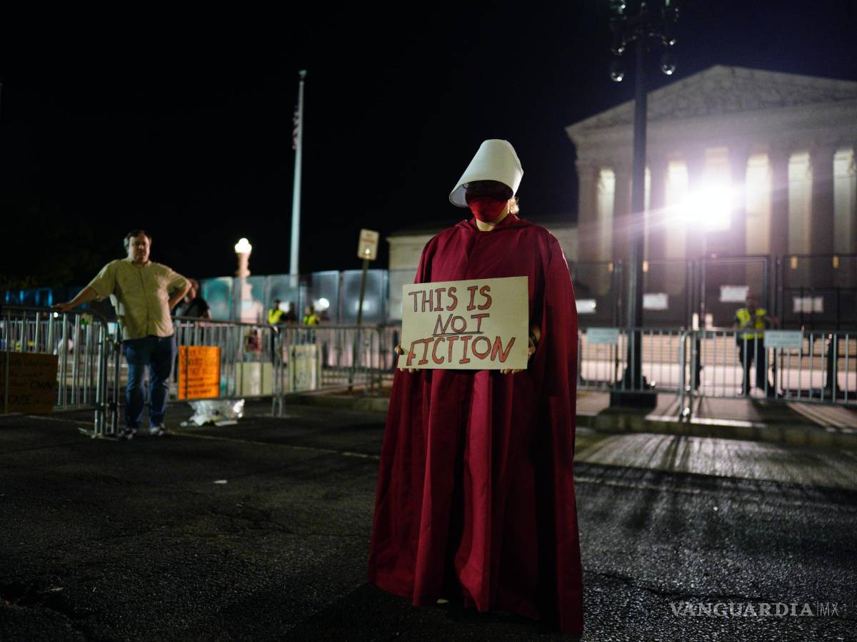 $!Los manifestantes protesta rente a la Corte Suprema después del atardecer en Washington.
