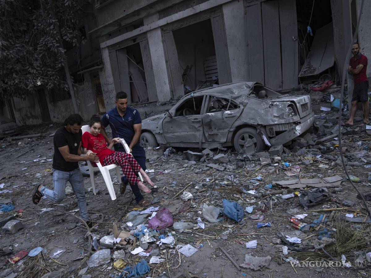 $!Palestinos caminan entre escombros luego de ataques israelíes contra una extensa zona de un vecindario en la Ciudad de Gaza, el martes 10 de octubre de 2023. Hamas, el grupo islamista que gobierna la Franja de Gaza, llevó a cabo un ataque sin precedentes el sábado contra Israel, en donde mató a más de 1.000 personas y secuestró a varias más. Israel respondió con intensos ataques aéreos contra el territorio que dejaron a cientos de palestinos muertos. (AP Foto/Fatima Shbair)