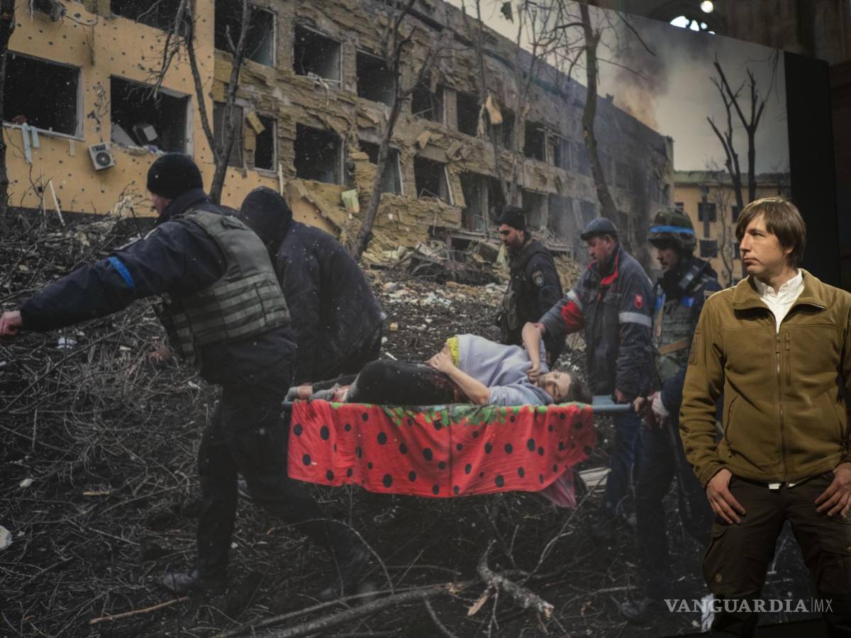 $!El ganador del premio World Press Photo of the Year, el fotógrafo de Associated Press Evgeniy Maloletka, frente a su imagen en Ámsterdam, Países Bajos.