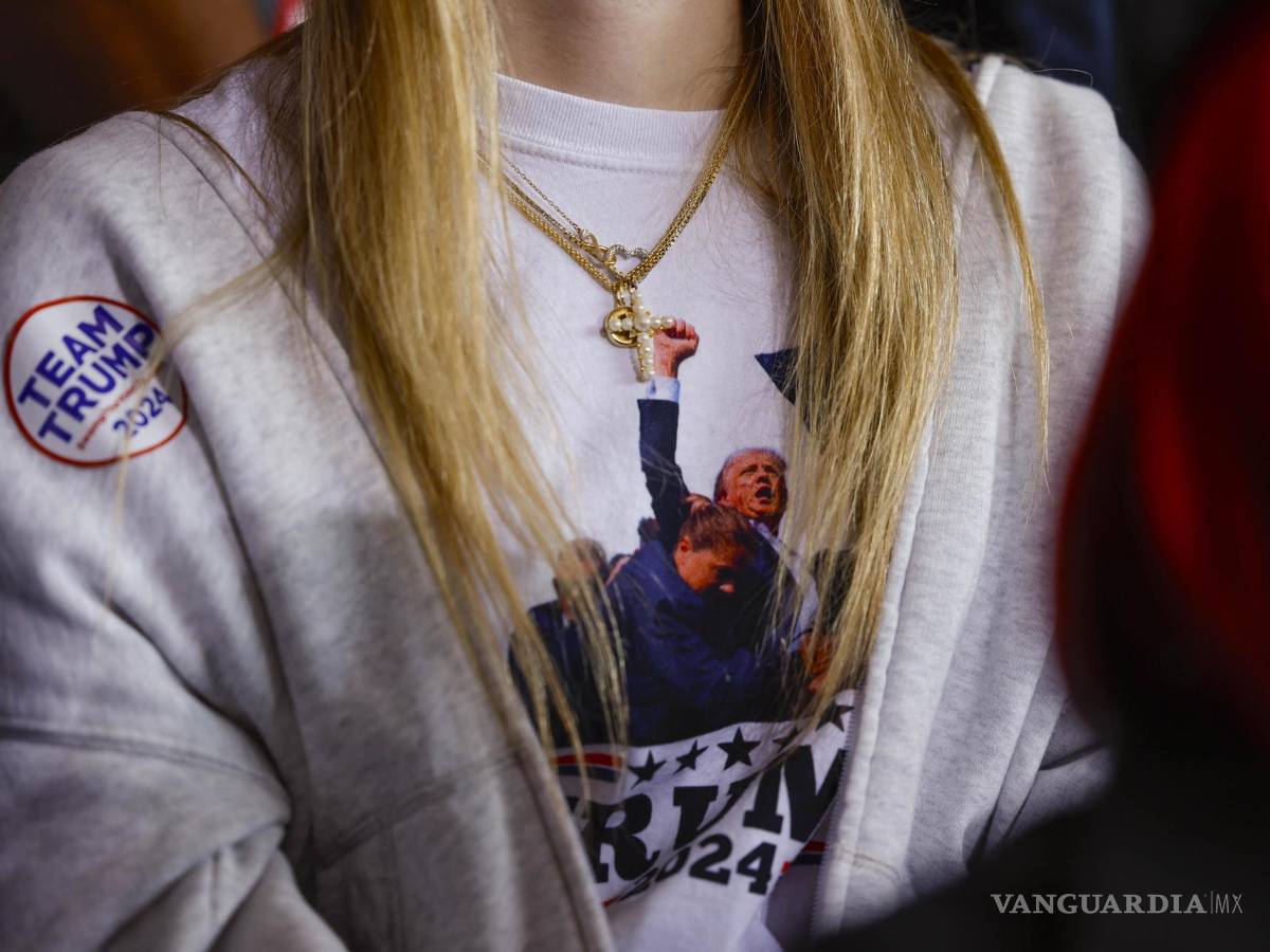 $!Una mujer escucha al candidato presidencial republicano Donald Trump en un mitin de campaña en el aeropuerto del condado de Dodge en Juneau, Wisconsin.