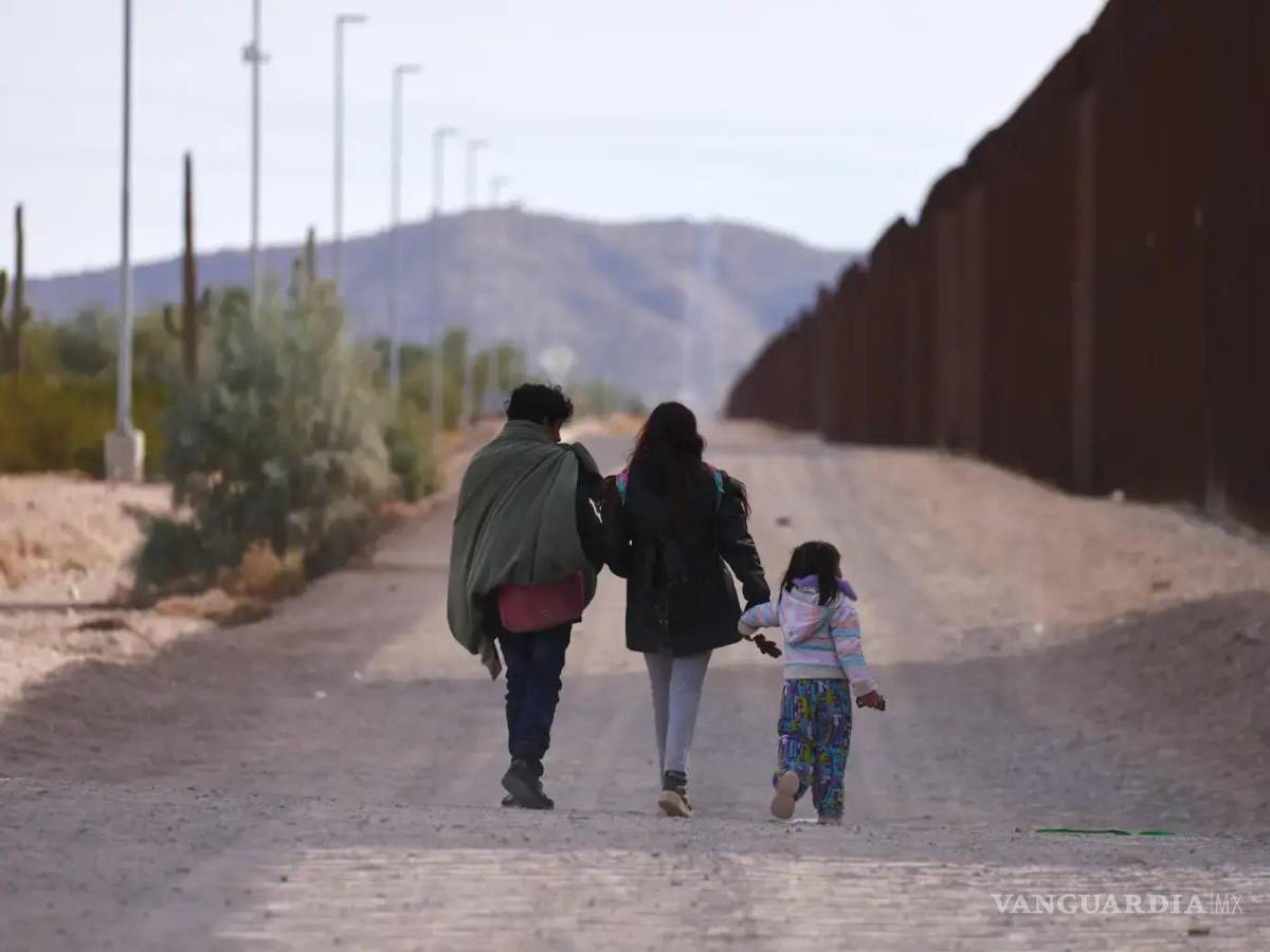 $!Una familia que camina a lo largo del muro fronterizo estadounidense en busca de la Patrulla Fronteriza para ser procesados en Lukeville, Arizona.