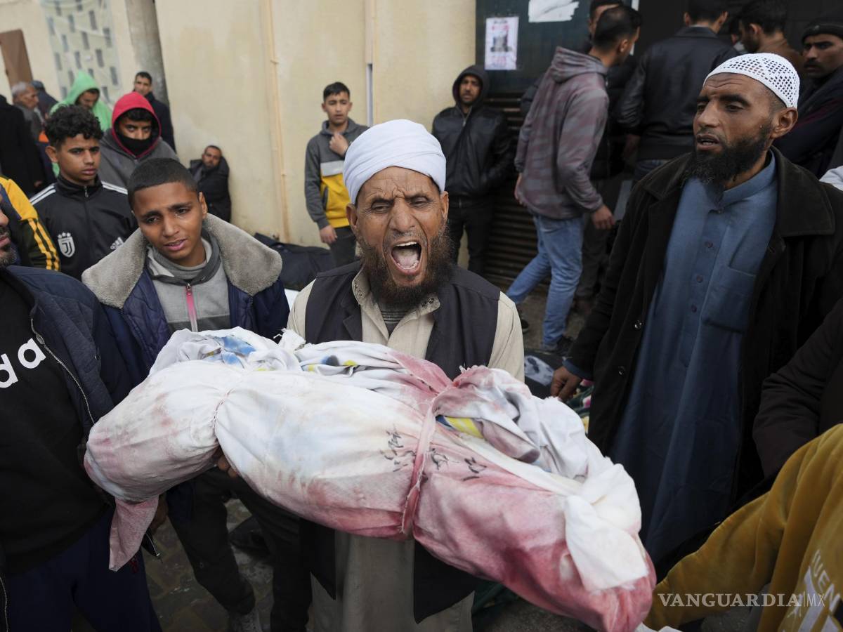 $!Un hombre llora al sostener en sus brazos el cuerpo de un niño fallecido tras los ataques israelíes.