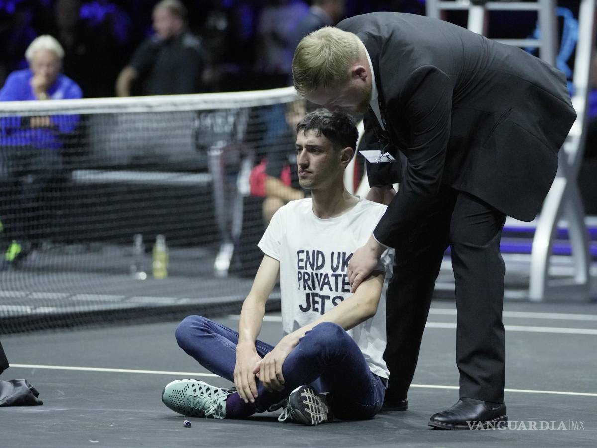 $!La seguridad se lleva a un hombre después de que se prendiera fuego en su brazo durante una protesta en el O2 de Londres.