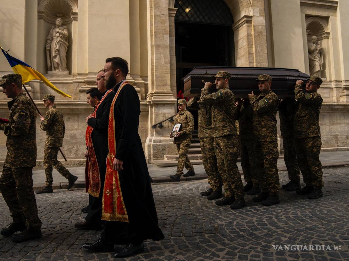 $!Soldados llevan los ataúdes de dos sargentos del ejército ucraniano durante su funeral en la iglesia de los Santos Pedro y Pablo en Leópolis, Ucrania.