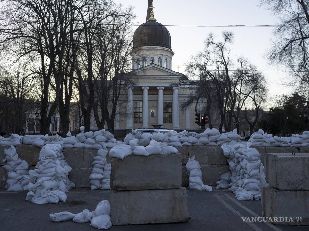 $!Bloques de concreto con sacos de arena bloquean una calle en Odesa, al sur de Ucrania, mientras al fondo se ve la catedral de Preobrazhensky.
