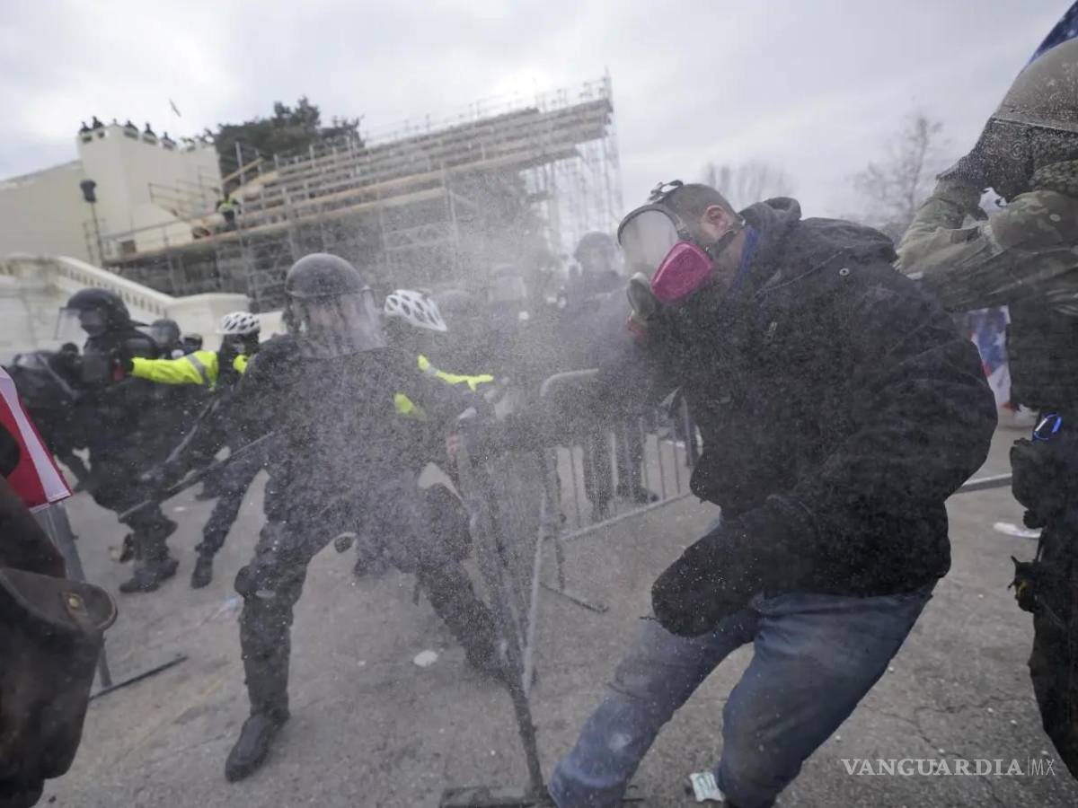 $!Partidarios del entonces presidente Donald Trump intentan atravesar una barrera policial en el Capitolio en Washington el 6 de enero de 2021.
