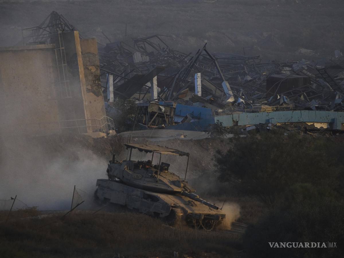 $!Soldados israelíes conducen un tanque dentro de la Franja de Gaza visto desde el sur de Israel.